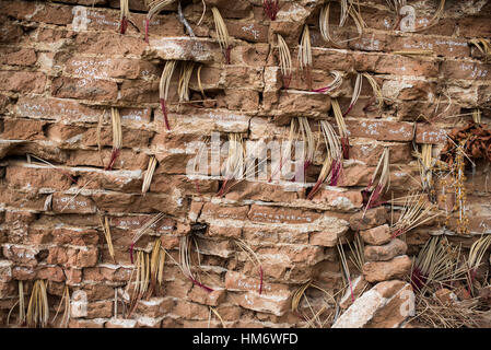 MINGUN, Myanmar - Incense sticks are burned by visitors to the Unfinished Pagoda and are inserted into gaps between the bricks. Mingun Pahtodawgyi, also known as the Unfinished Pagoda of Mingun, was commissioned by King Bodawpaya in 1790. The current structure stands 50 meters tall; the plans called for it to reach a total height of 150 meters when completed. The structure is solid and built entirely of bricks. An earthquaker in March 1839 tore large cracks in the structure. Stock Photo