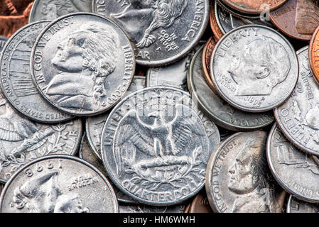 A pile of American currency coins, including quarters, dimes, nickels, and pennies. Stock Photo