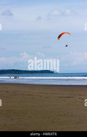 A powered parachute flies above Playa Hermosa at Uvita, Costa Rica. Stock Photo