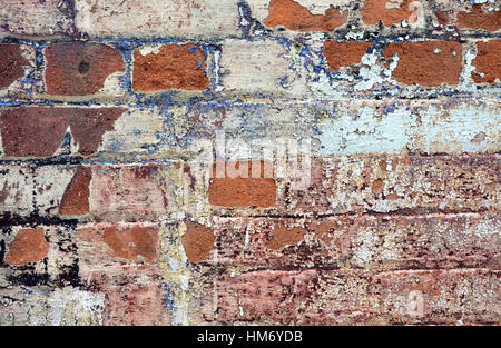 Old cracked rendered wall from historic building with exposed brick and mortar and peeling paint. Grunge texture background Stock Photo