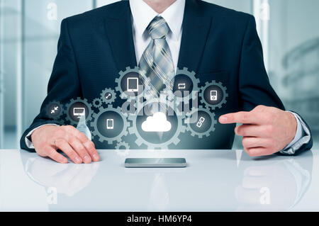 Businessman holding a cloud connected to many objects on virtual screen concept about the internet of things Stock Photo