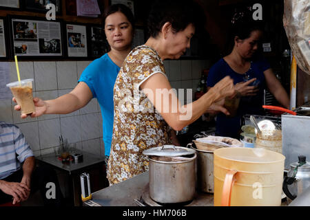 Phan Dinh Phung street, Ho Chi Minh city, Viet Nam - FEB 7: Unidentified woman with private business at home by cafe store. Coffee is favorite drink a Stock Photo