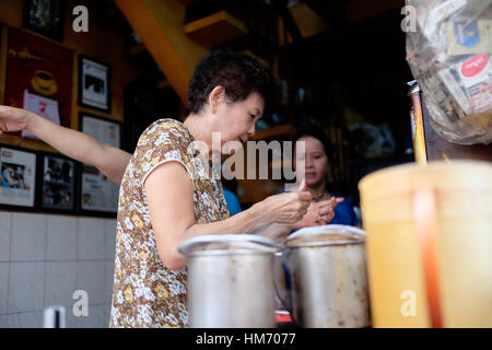 Phan Dinh Phung street, Ho Chi Minh city, Viet Nam - FEB 7: Unidentified woman with private business at home by cafe store. Coffee is favorite drink a Stock Photo