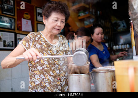 Phan Dinh Phung street, Ho Chi Minh city, Viet Nam - FEB 7: Unidentified woman with private business at home by cafe store. Coffee is favorite drink a Stock Photo