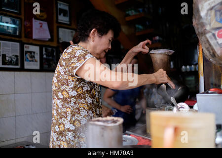 Phan Dinh Phung street, Ho Chi Minh city, Viet Nam - FEB 7: Unidentified woman with private business at home by cafe store. Coffee is favorite drink a Stock Photo