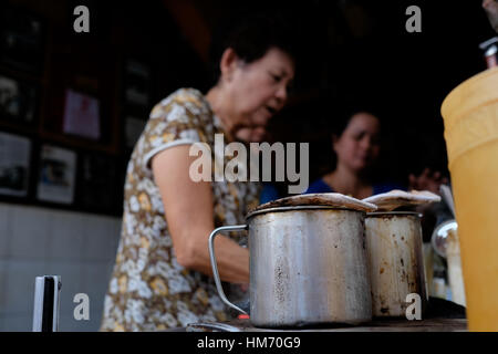 Phan Dinh Phung street, Ho Chi Minh city, Viet Nam - FEB 7: Unidentified woman with private business at home by cafe store. Coffee is favorite drink a Stock Photo