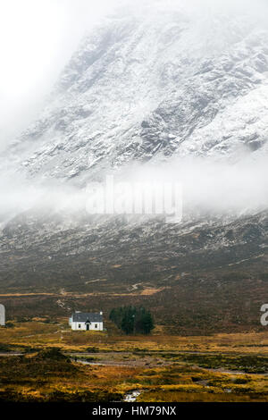 Scottish cottage beneath a snowy mountain side near Glencoe,Scotland Stock Photo