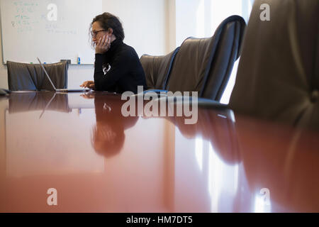 Young business woman sitting in conference room with laptop Stock Photo