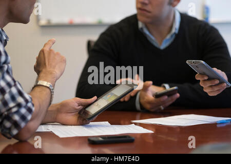 Mid section of business people using mobile devices Stock Photo