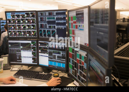 Young man working on group of computer monitors Stock Photo