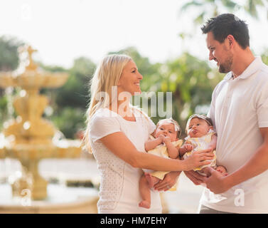 Happy family with two baby girls (2-5 months) at park Stock Photo