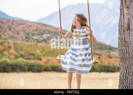 Girl (8-9) sitting on swing Stock Photo