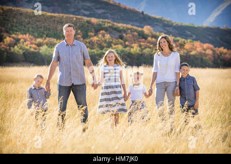 USA, Utah, Provo, Family with three children (4-5, 6-7, 8-9) standing in field Stock Photo