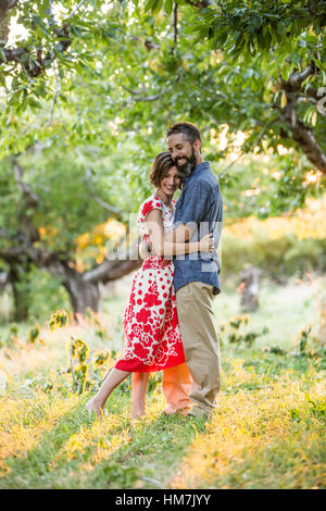 Couple embracing in cherry orchard Stock Photo
