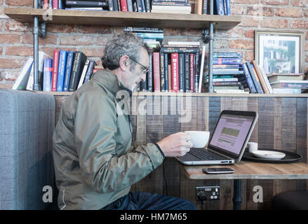 Mature man with laptop in pub. Stock Photo