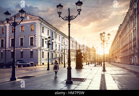 Woman in white jacket walking Malaya Konyushennaya  street with Lanterns and ol buildings in Saint Petersburg Stock Photo