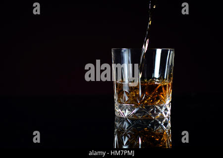 Pouring Bourbon whiskey into glass Stock Photo