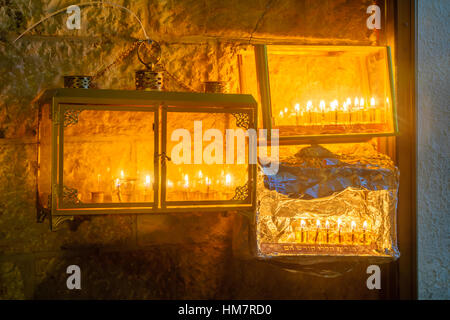 Traditional Menorahs (Hanukkah Lamps) with olive oil candles, in the Jewish quarter, Jerusalem Old City, Israel. Text is: These candles are sacred Stock Photo