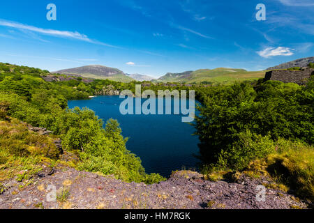 Looking across the disused Dorothea Slate Quarry to Snowdon, Nantlle, Gwynedd, Wales, United Kingdom. Flooded with water. Stock Photo