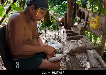 A men of The Ngobe Bugle Indian Village Of Salt Creek Near Bocas Del Toro Panama do wood souvenirs. Salt Creek (in Spanish: Quebrada Sal) is a Ngöbe B Stock Photo