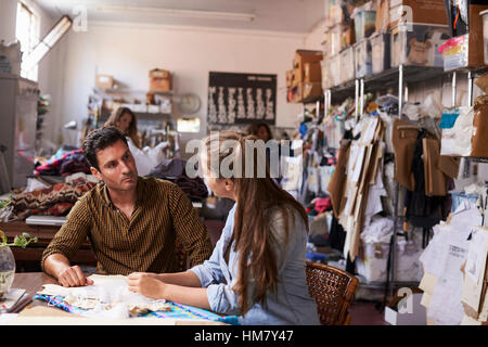 Male manager training apprentice at a clothing design studio Stock Photo