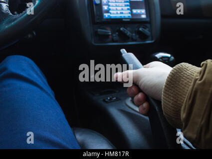 Closeup view of man pulling handbrake lever in car Stock Photo