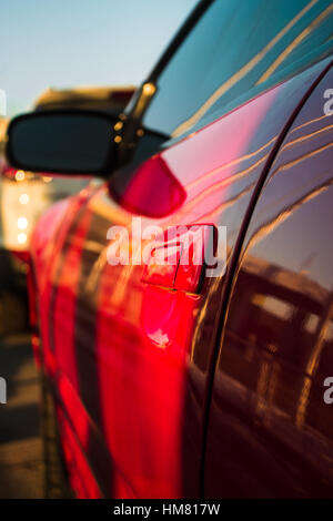 Shining handle of red car door with blurred background Stock Photo