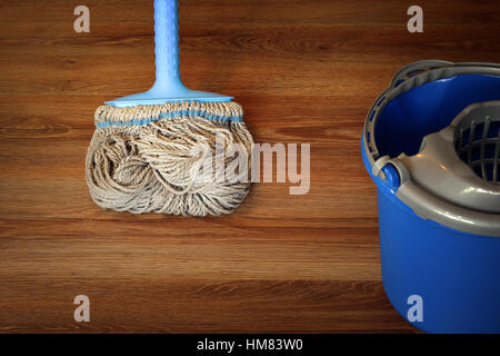 cleaning equipment on wooden floor, mop and blue bucket Stock Photo