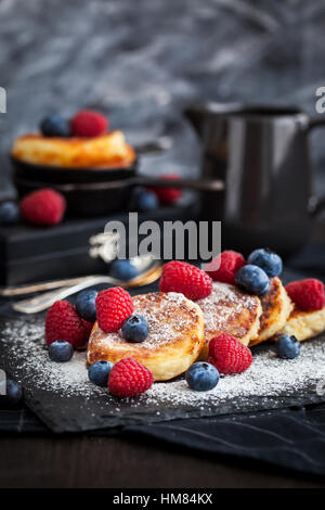 Cottage cheese pancakes decorated with fresh raspberries and blueberries Stock Photo