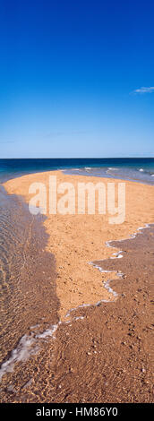 The rising tide swallows a small sand island. Stock Photo