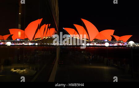 Sydney Australia - Jan 28 2017. Sydney Opera House and glass reflections at the end of the pier. Opera House bathed in red for Chinese Lunar New Year Stock Photo