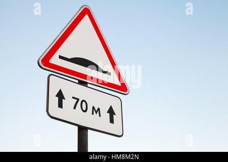 Speed Bump. Warning road sign over bright blue sky background Stock Photo