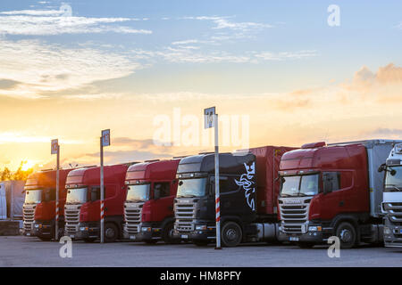 Narva, Estonia - August 20, 2016: Scania Heavy trucks loaded with goods trailers, parked in waiting area on Estonian-Russian state border crossing. In Stock Photo