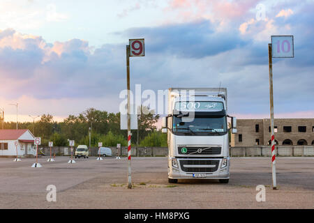 Narva, Estonia - August 20, 2016: Volvo heavy truck loaded with goods trailer, parked in waiting area on Estonian-Russian state border crossing. Inter Stock Photo
