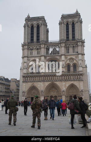 Armed soldiers patrol around the Notre Dame cathedral in Paris in winter Stock Photo