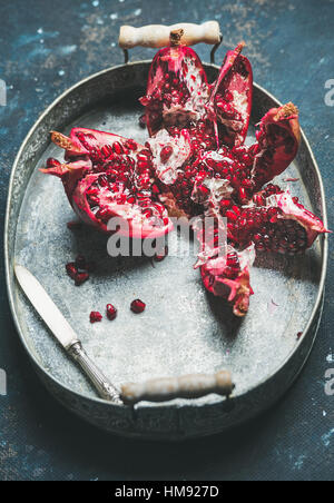 Fresh ripe pomegranate broken in pieces in metal tray Stock Photo