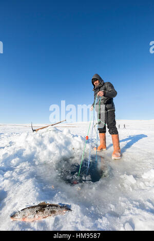 Ardahan, Turkey - January 14, 2017: Fishermen fishing by using fishnet on frozen Cildir lake in Ardahan city of Turkey on January 14, 2017. Stock Photo