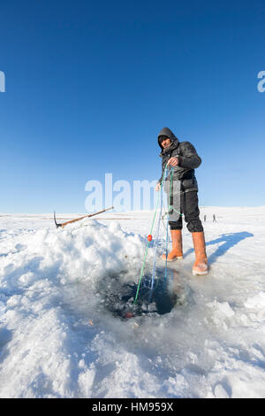 Ardahan, Turkey - January 14, 2017: Fishermen fishing by using fishnet on frozen Cildir lake in Ardahan city of Turkey on January 14, 2017. Stock Photo