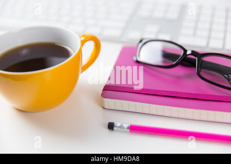 Coffee cup and keyboard on white office desk Stock Photo