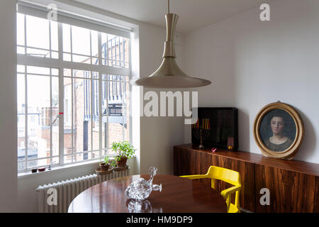 interior of an english living room with a table, chairs, painting with the portrait of a woman and chest and candelabra Stock Photo
