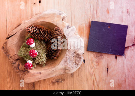 chalkboard and wooden bowl with pinecones and mushrooms on wooden table Stock Photo