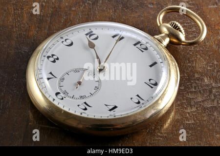 antique Swiss 14k gold pocket watch on wooden background Stock Photo