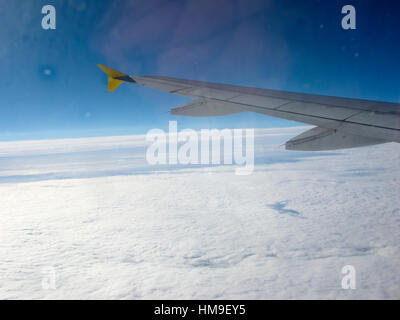 Look out over white clouds through aircraft window flying Stock Photo