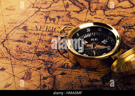 old compass on vintage world map Stock Photo