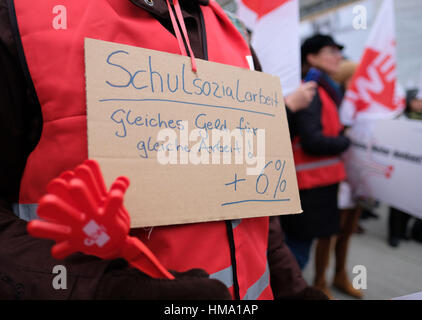 Hanover, Germany. 1st February 2017. A GEW member holds up a sign written with 'school social work - the same money for the same work! 6%' during a warning strike in downtown Hanover, Germany, 01 February 2017. Classes were cancelled Wednesday at around 20 schools in Lower Saxony due to a warning strike. The Education and Science Workers' Union (GEW) reported that several hundred teachers and school employees took part in the strike. The union is demanding a 6 percent increase in wages. Photo: Peter Steffen/dpa Stock Photo