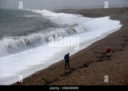 Chesil Cove, Portland, UK. 2nd Feb, 2017. UK Weather. Strong winds and high tides this morning bring huge waves crashing onto the beach near beach walker. Credit: JOHN GURD MEDIA/Alamy Live News Stock Photo