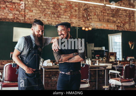 Shot of hairdresser with a man standing at barbershop. Hairstylist and client at salon Stock Photo