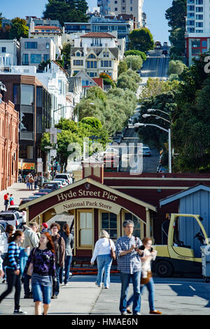 Pedestrians on historic Hyde Street Pier and Hyde Street (background), San Francisco, California USA Stock Photo