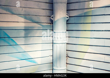 graffiti painted wall corner and gutter in white and blue Stock Photo