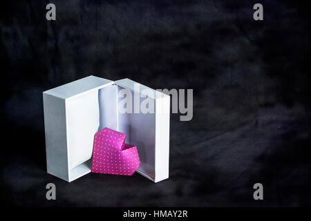 Valentine's heart in a open gift box. Origami Heart done with pink polka dot paper over abstract background. Stock Photo